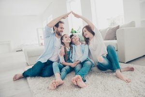 Family in their living room, sitting on a white carpet. Compare Insurance Ireland.
