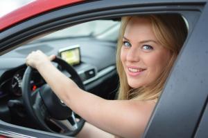 young driver driving a red car