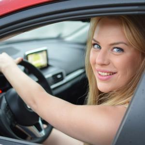 young driver driving a red car